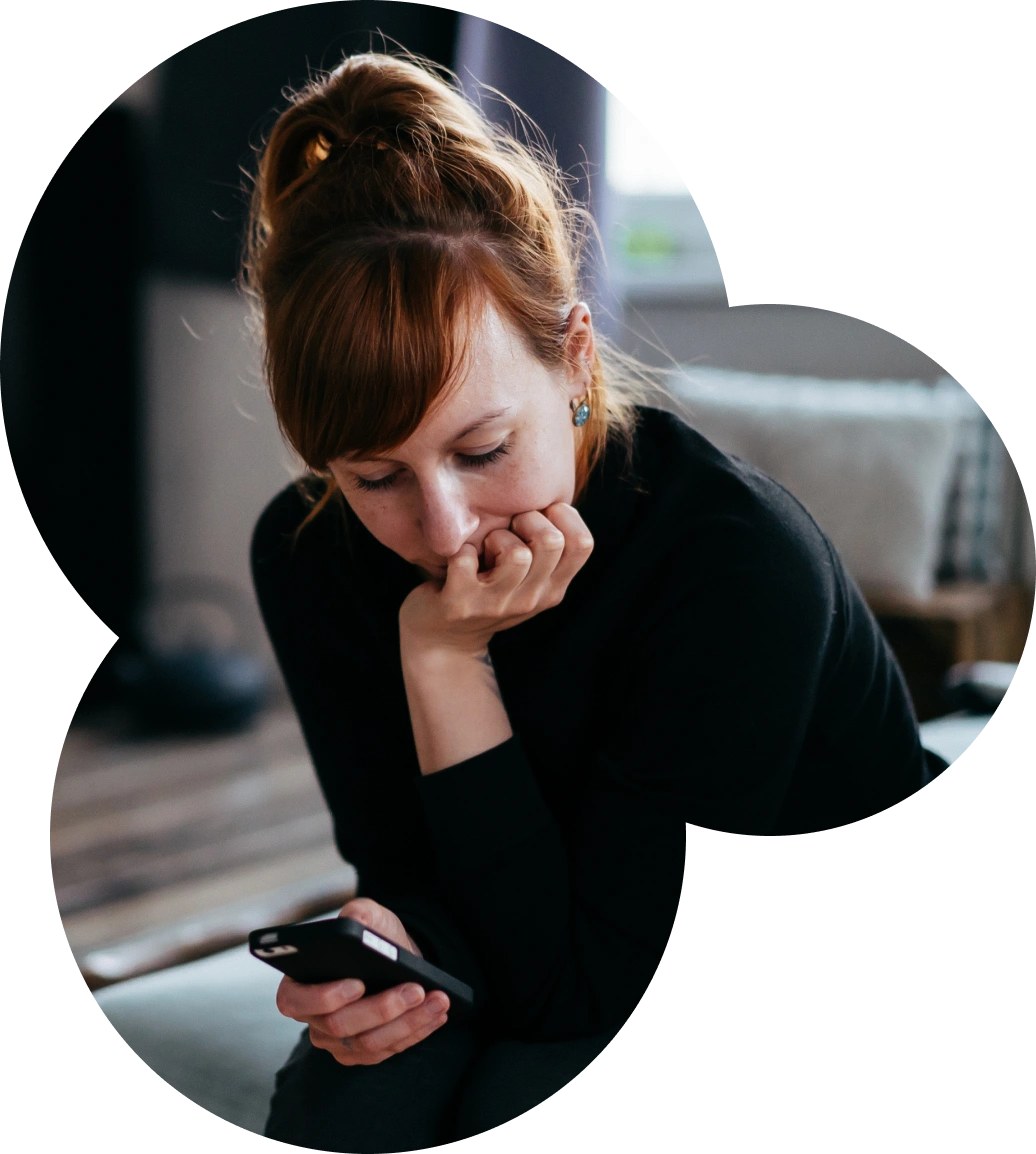 mulher jovem olhando para o celular, pensando em contratar criação de sites